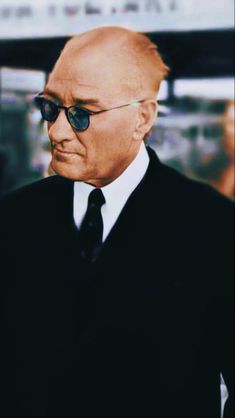 an older man wearing sunglasses and a black suit