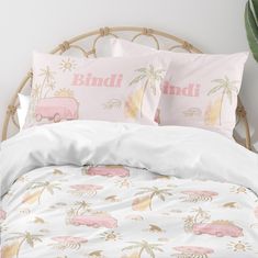 a bed with pink and white bedspreads, palm trees and cars on them