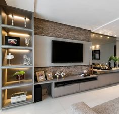 a modern living room with built - in entertainment center and large flat screen tv mounted on the wall