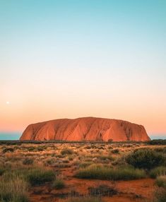 a large rock in the middle of an open field