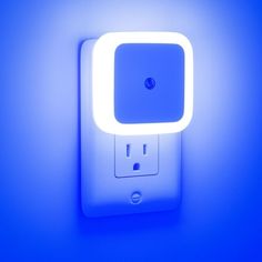 a white light switch on a wall with a blue back ground and the light is turned on