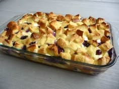 a glass casserole dish filled with bread and blueberry cobbler toppings