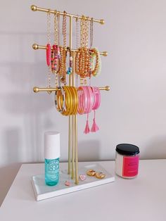 a jewelry stand with bracelets, nail polish and other accessories on it next to a can