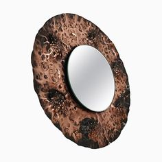 a round mirror sitting on top of a wooden table