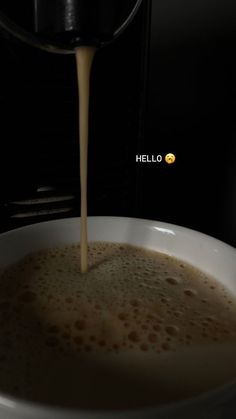 coffee being poured into a white bowl on top of a stove with the words hello written below it