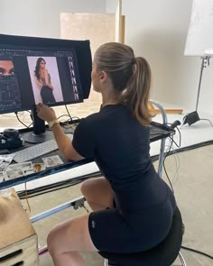 a woman sitting in front of a computer monitor