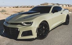 a white chevrolet camaro is parked on the street