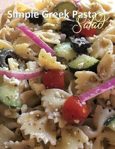 a pasta salad with tomatoes, cucumbers, and other veggies on it