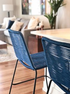 two blue chairs sitting on top of a hard wood floor next to a kitchen counter