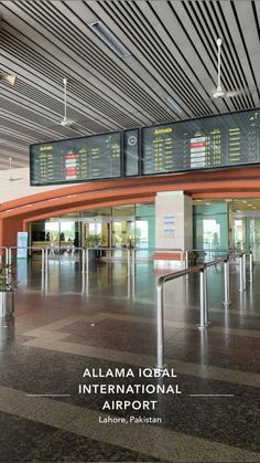 an airport terminal with the information board above it and luggage carousels on either side