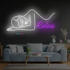 a neon sign that reads relax in front of a couch