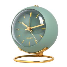 an alarm clock on a metal stand with gold trim around the face and hands, sitting on a white background