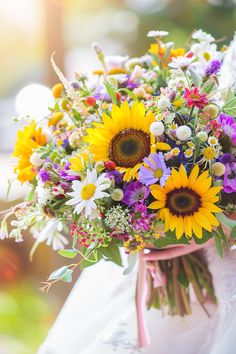 a bridal bouquet with sunflowers and other flowers