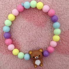 a bracelet with a teddy bear and multicolored beads on it's side