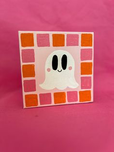 a pink and orange card with a ghost on it