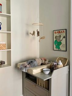 a baby crib in the corner of a room with bookshelves and toys