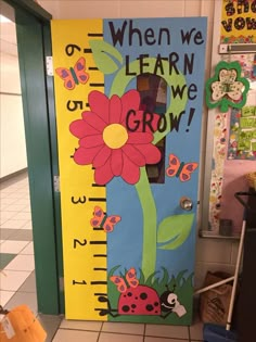 a classroom door decorated with a growth chart and flowers