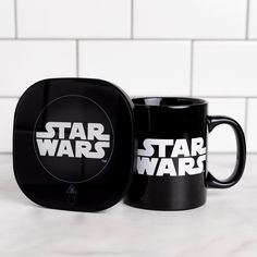 two star wars coffee mugs sitting next to each other on top of a counter