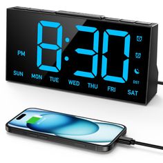 an alarm clock is connected to a cell phone and plugged into a charger