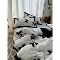 an unmade bed with black and white pillows