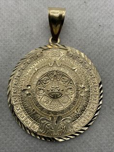 a gold pendant with an intricate design on it