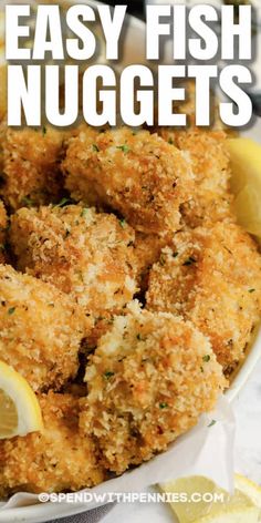 fried fish nuggets in a white bowl with lemon wedges