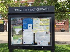 a sign in front of a building that says community noticeboard on the side of it