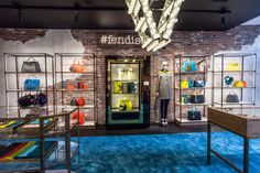 a display case with handbags and purses on it's sides in front of a brick wall