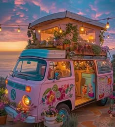 an old vw bus decorated with flowers and plants is parked on the beach at sunset