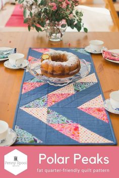 a table topped with a donut covered in powdered sugar next to cups and saucers