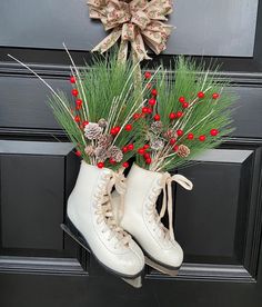 a pair of white ice skates with pine cones and red berries on the front door