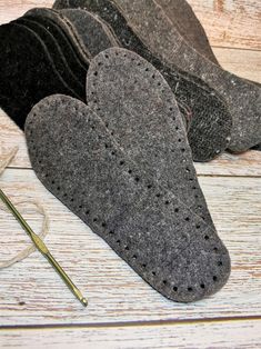 four pairs of felt mittens sitting on top of a wooden floor