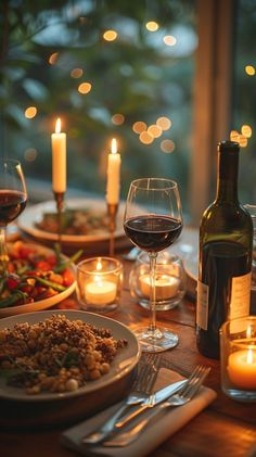 a dinner table with wine, food and candles