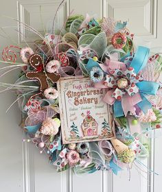 a wreath is hanging on the door with an old fashioned sign and ribbons attached to it