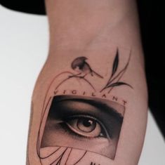 a person with a tattoo on their arm that has an eye and the words vigilant