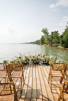 chairs are set up on the dock for an outdoor wedding ceremony by the water's edge