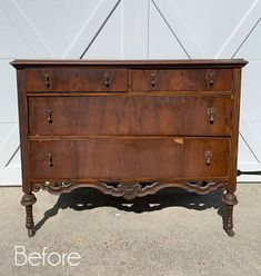 an old chest of drawers sitting in front of a garage door