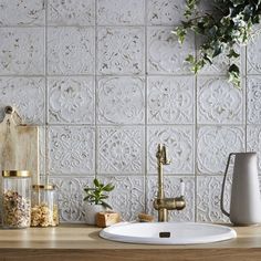 a white sink sitting on top of a wooden counter next to a vase filled with flowers