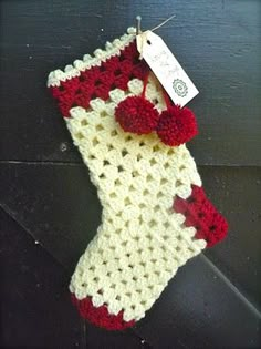 a red and white crocheted stocking hanging from a hook