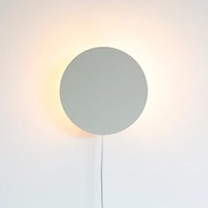 a round light that is on the side of a wall with a white ball attached to it