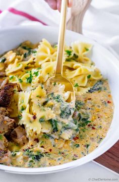 a white bowl filled with pasta and meat