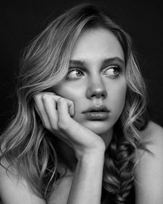 black and white photograph of a woman with her hand on her chin looking at the camera