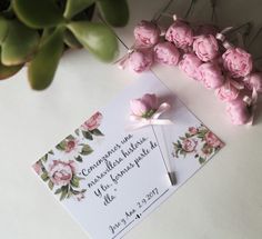 some pink flowers and a white card on a table