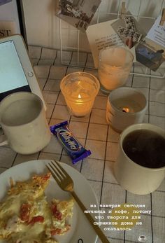 there is a plate of food on the table next to two cups and a cell phone