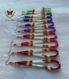 a row of multicolored beaded earrings on a white cloth with butterflies in the background