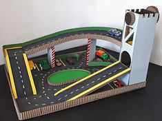 a toy train set with cars and trucks on the tracks next to a sign that says how to make car track with elevator