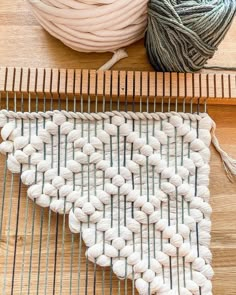 two skeins of yarn sitting on top of a table next to a ball of yarn