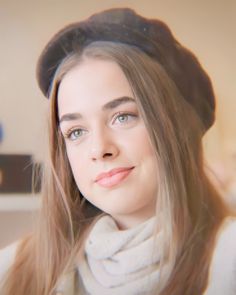 a woman with long hair wearing a hat and scarf