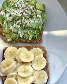 two pieces of bread with bananas and lettuce on them sitting on a plate