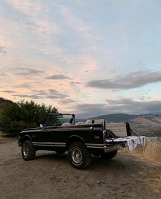 a pickup truck parked on the side of a dirt road